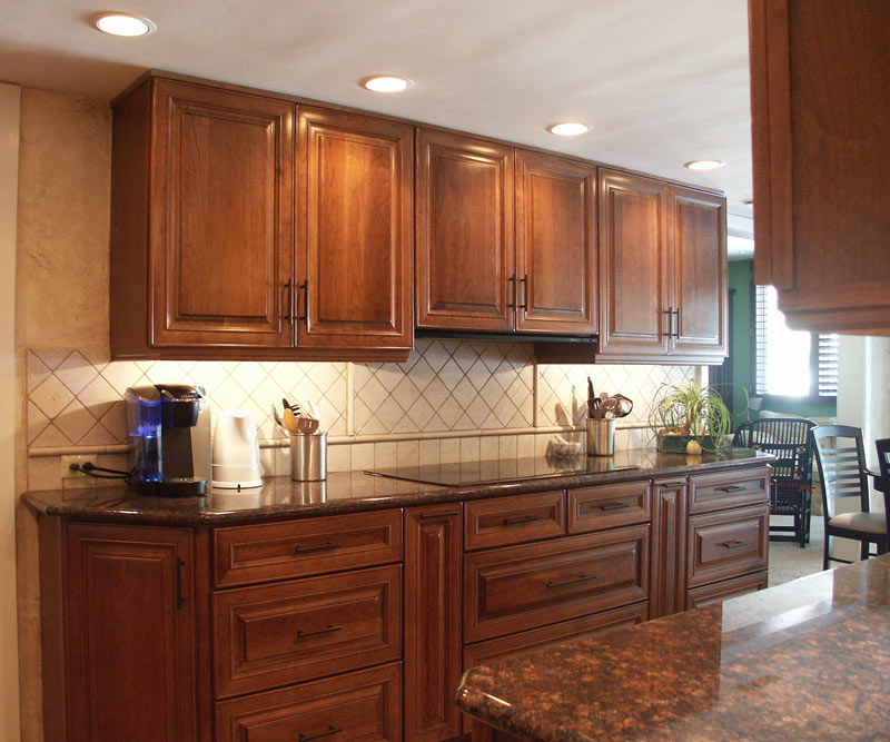 traditional galley kitchen with double wall ovens and cherry kraftmaid kitchen cabinets created by morris black